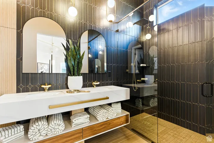 Full bath featuring double vanity, a walk-in shower, and tile walls. WOW!