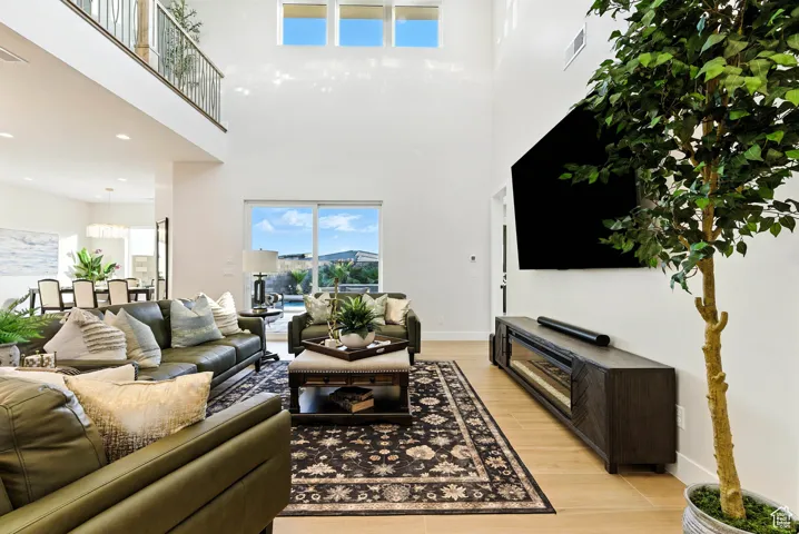 Living area with light wood finished floors and a high ceiling