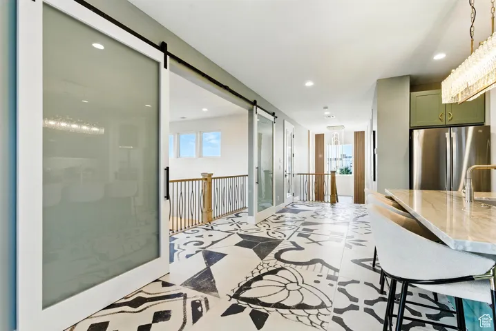 Corridor with Juliet style inner balcony with large glass sliding doors and recessed lighting.