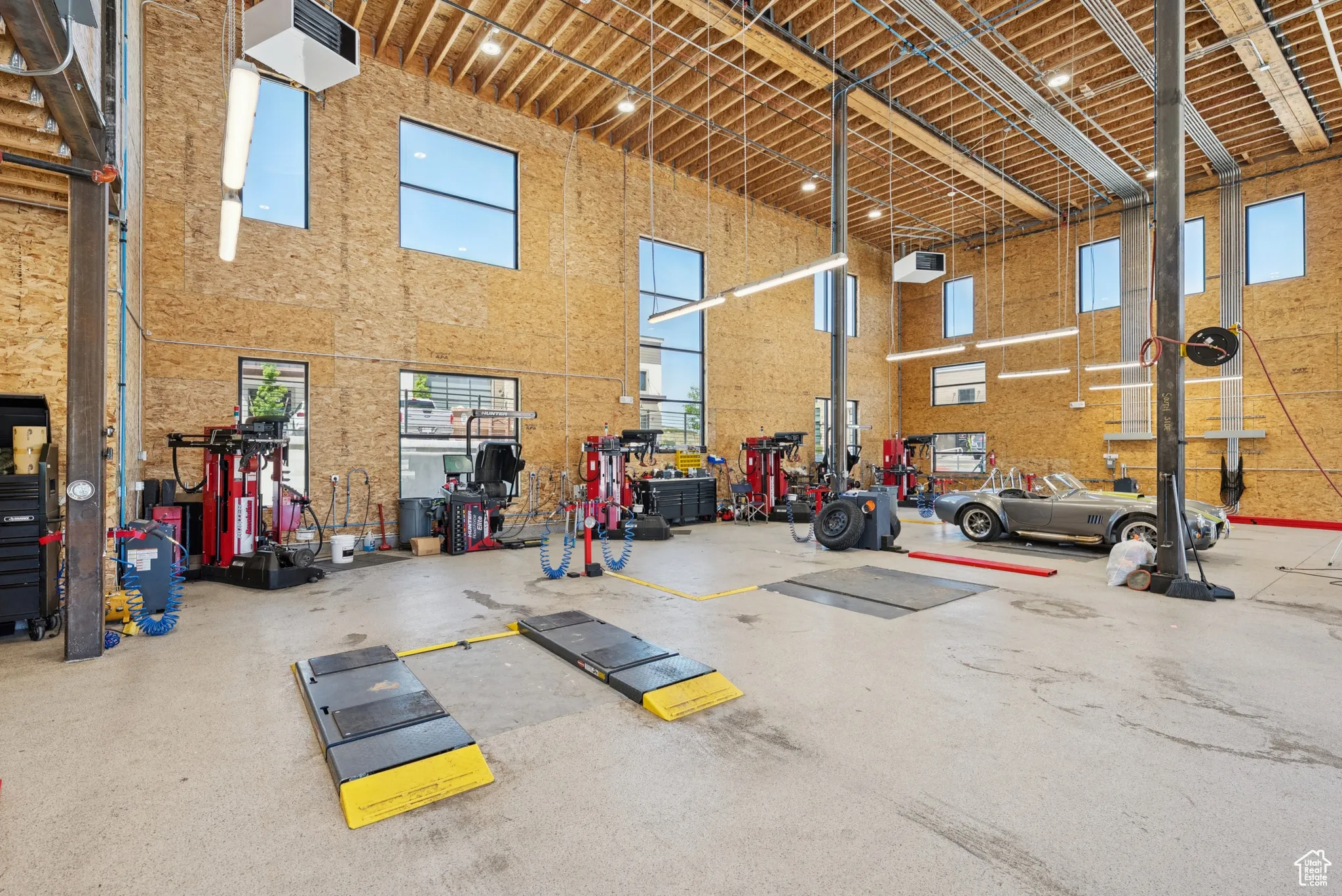 Gym with a high ceiling, a workshop area, and a garage