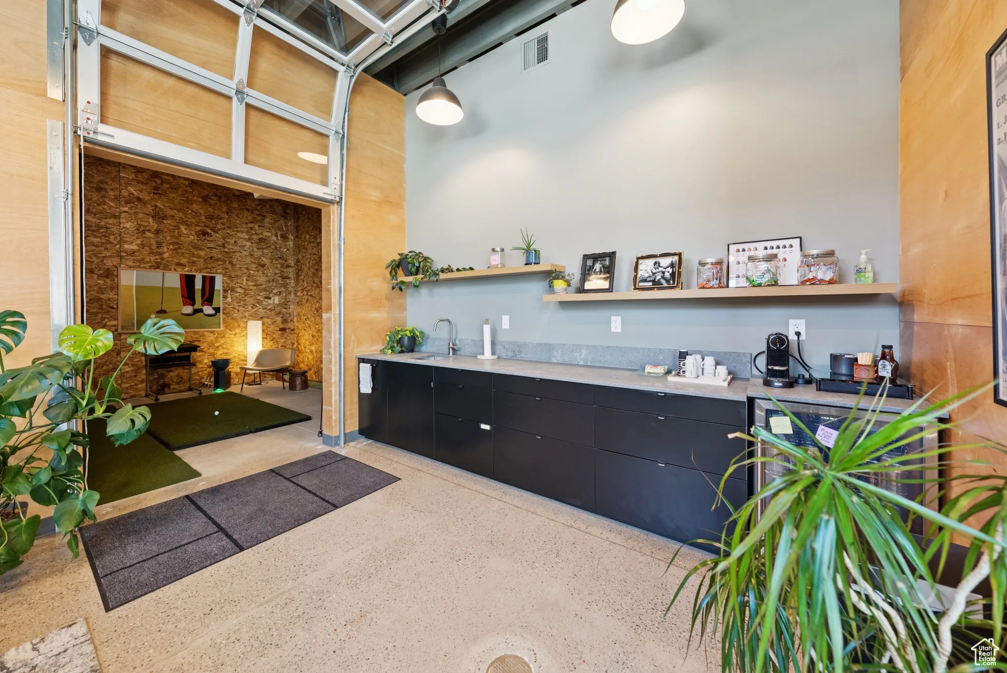 Miscellaneous room featuring dark aggregate flooring and a towering ceiling