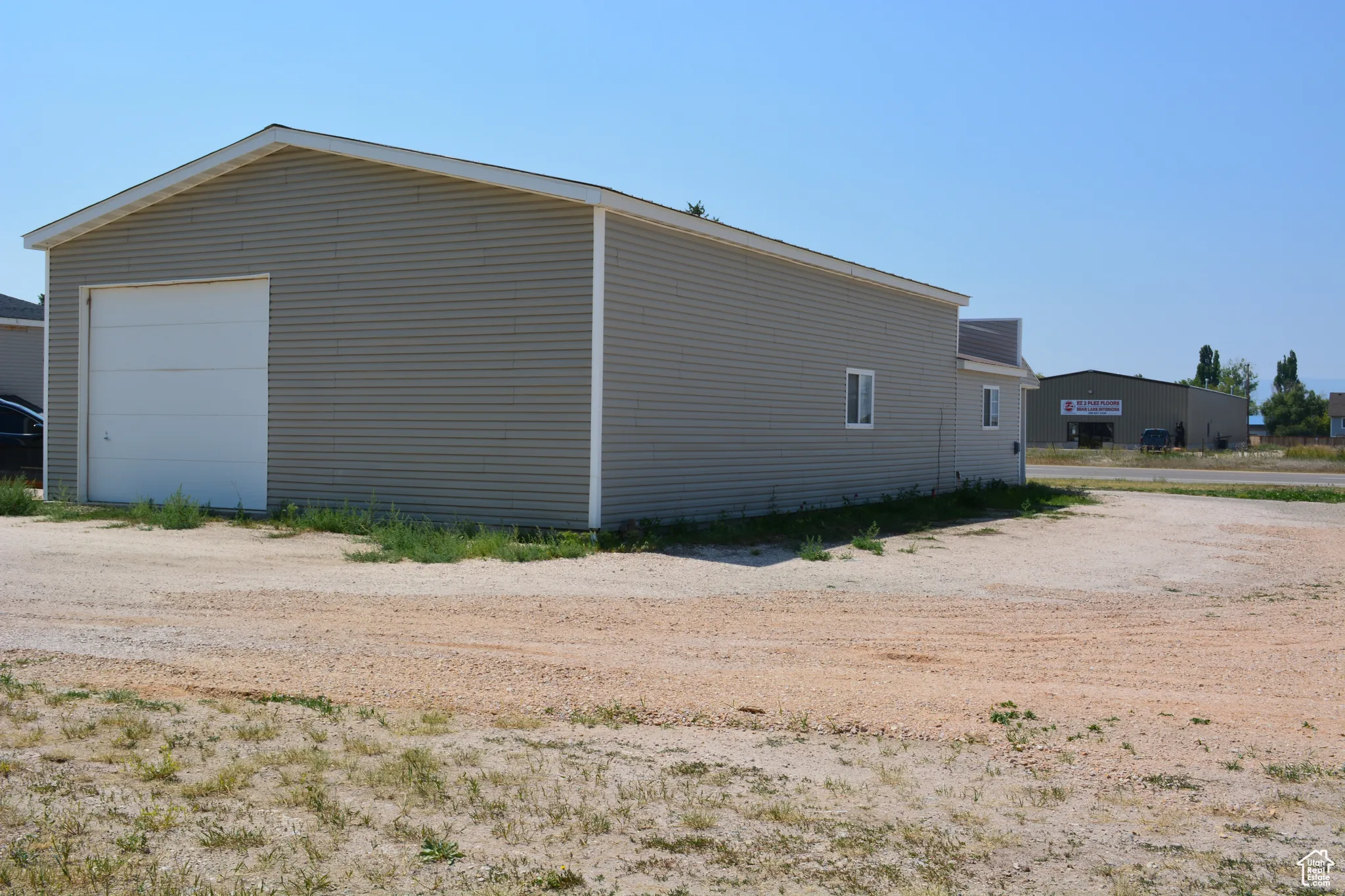 View of home's exterior featuring a detached garage and an outbuilding