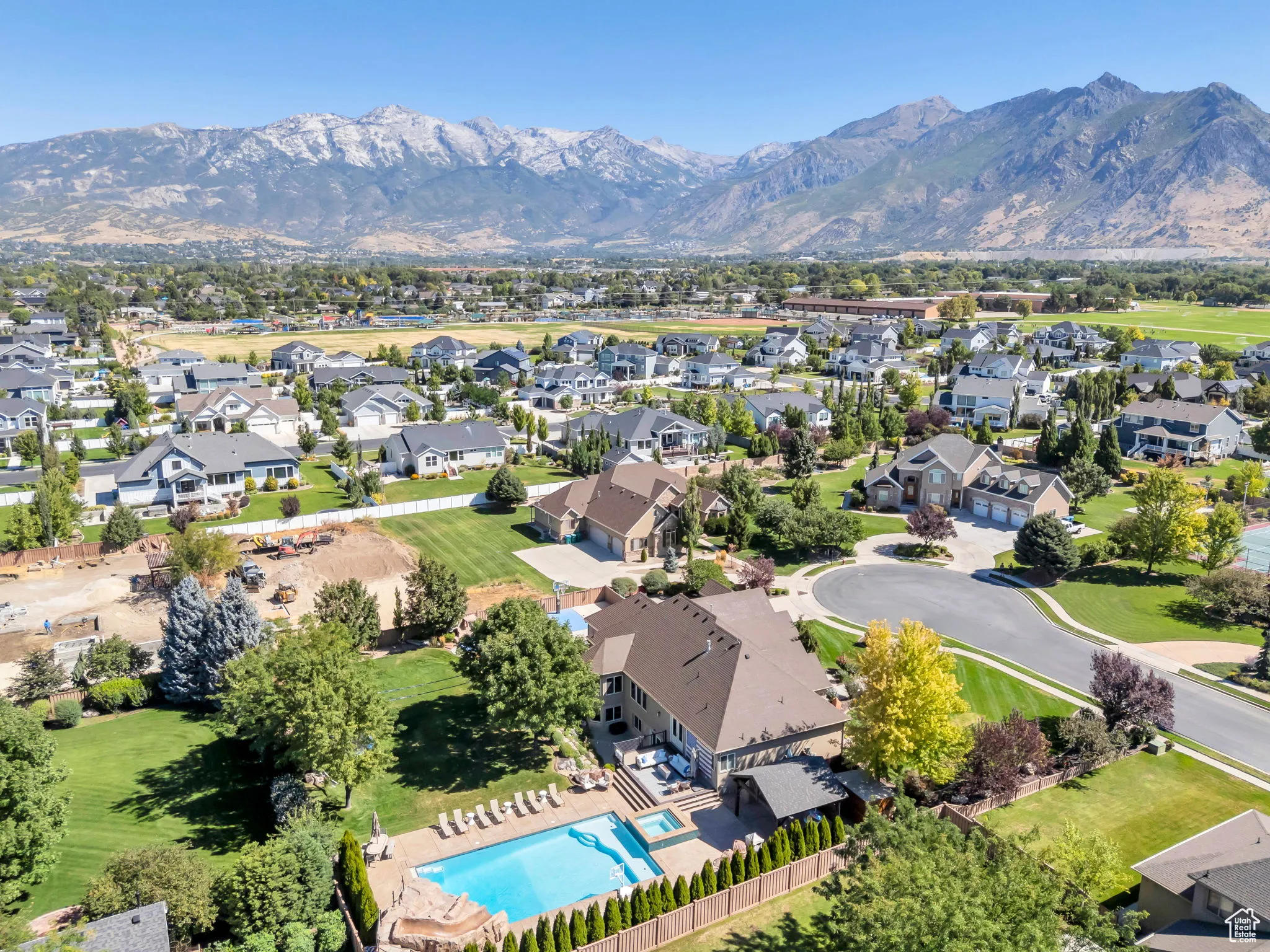 Aerial perspective of suburban area with a pool area and a mountain backdrop