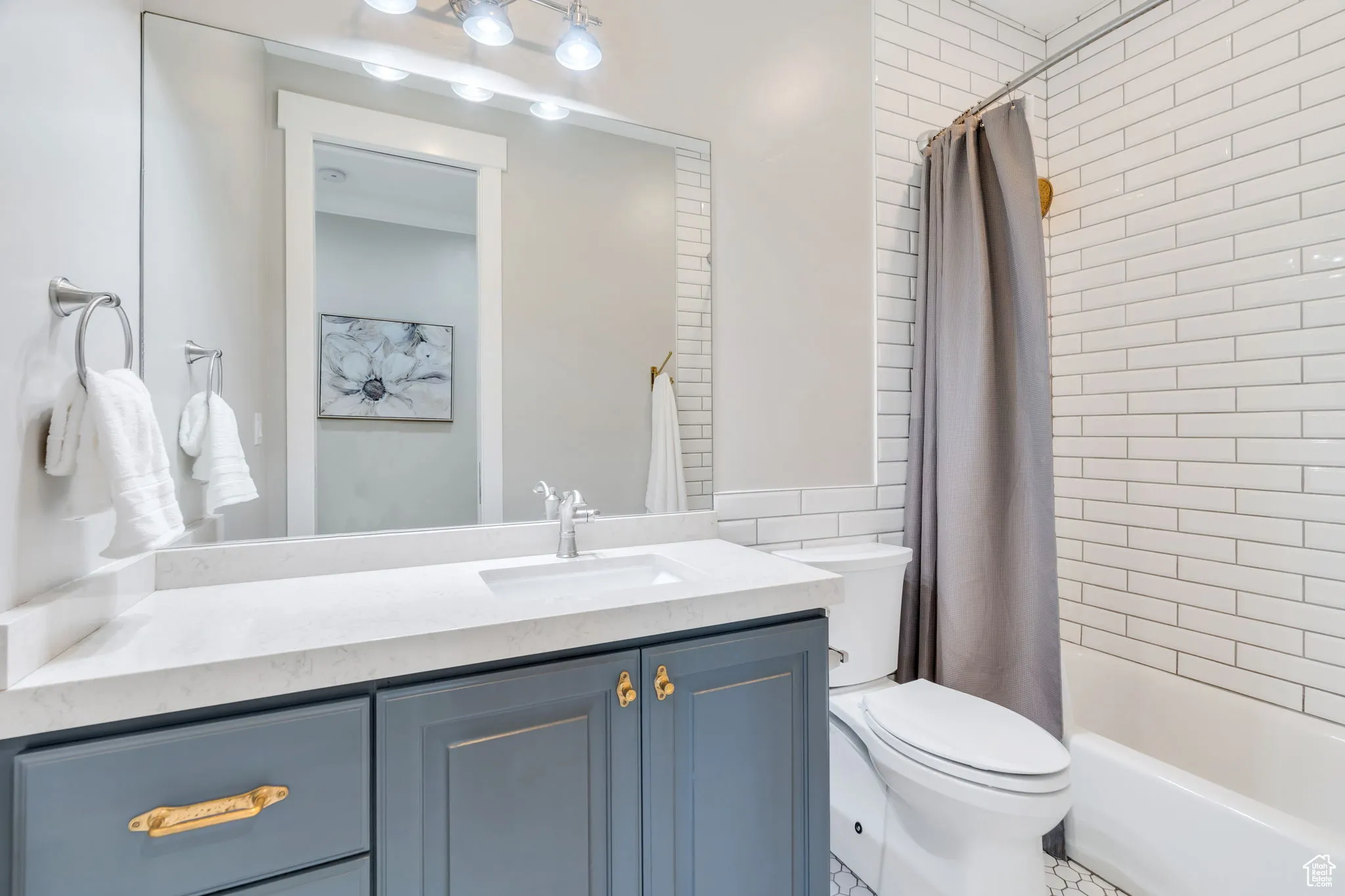 Full bath with shower / bath combo with shower curtain and vanity