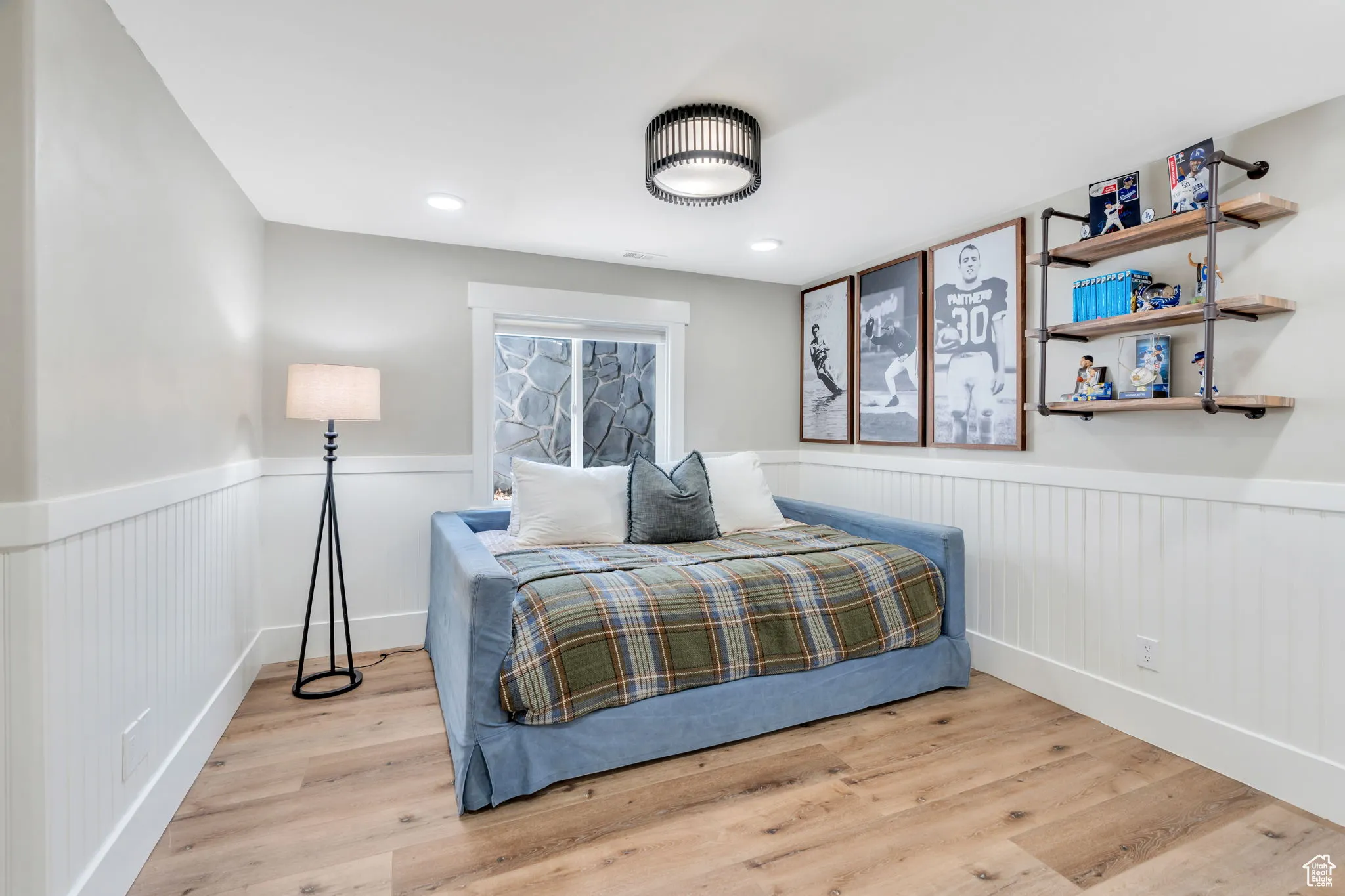 Bedroom with wood finished floors, wainscoting, and recessed lighting