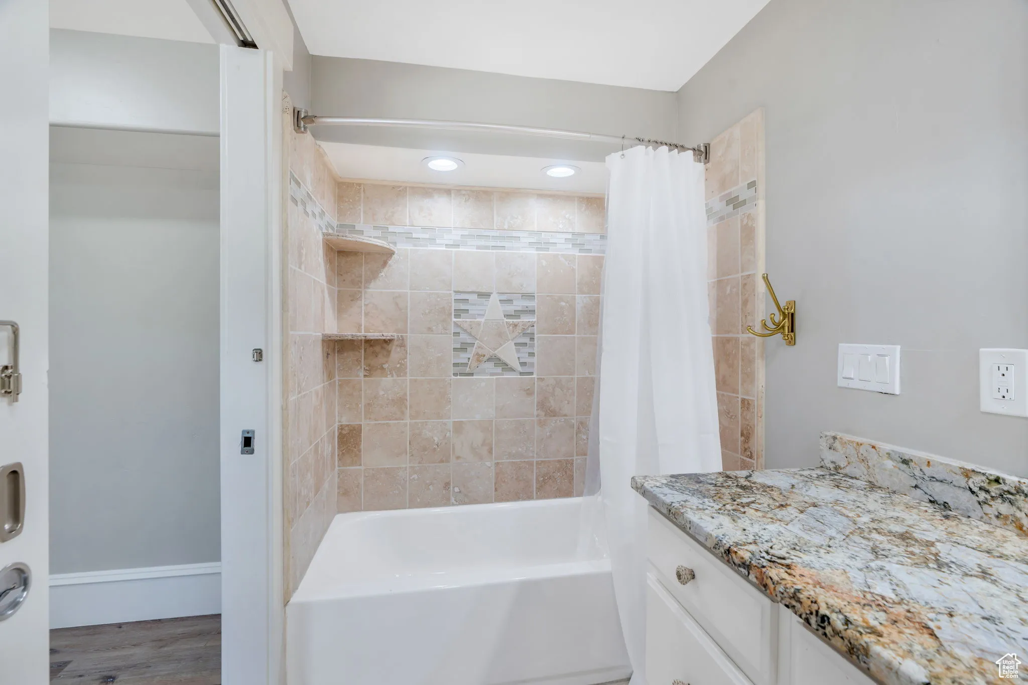Full bath featuring shower / tub combo with curtain, vanity, and wood finished floors