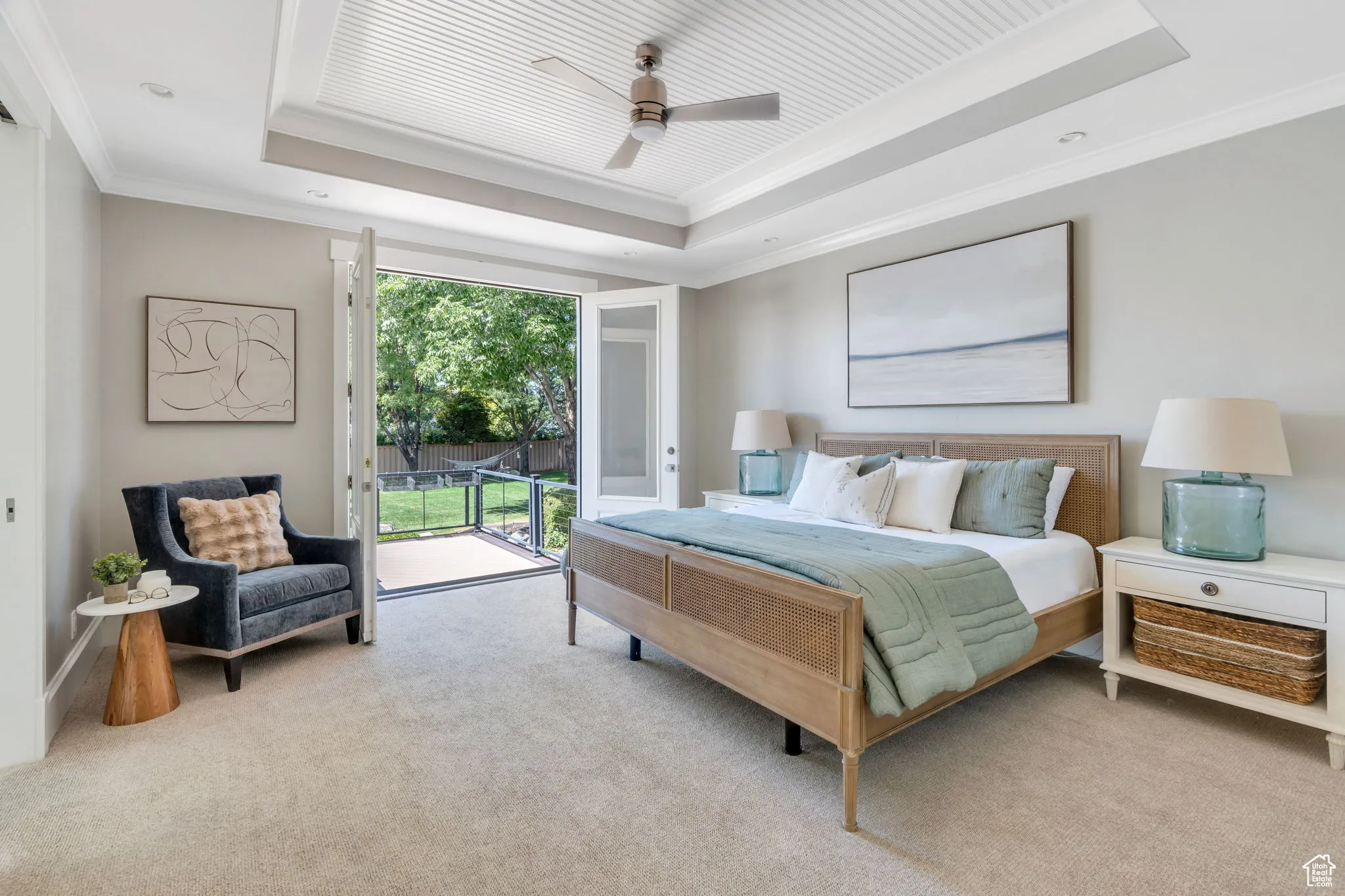 Bedroom featuring carpet floors, a raised ceiling, ornamental molding, access to outside, and a ceiling fan
