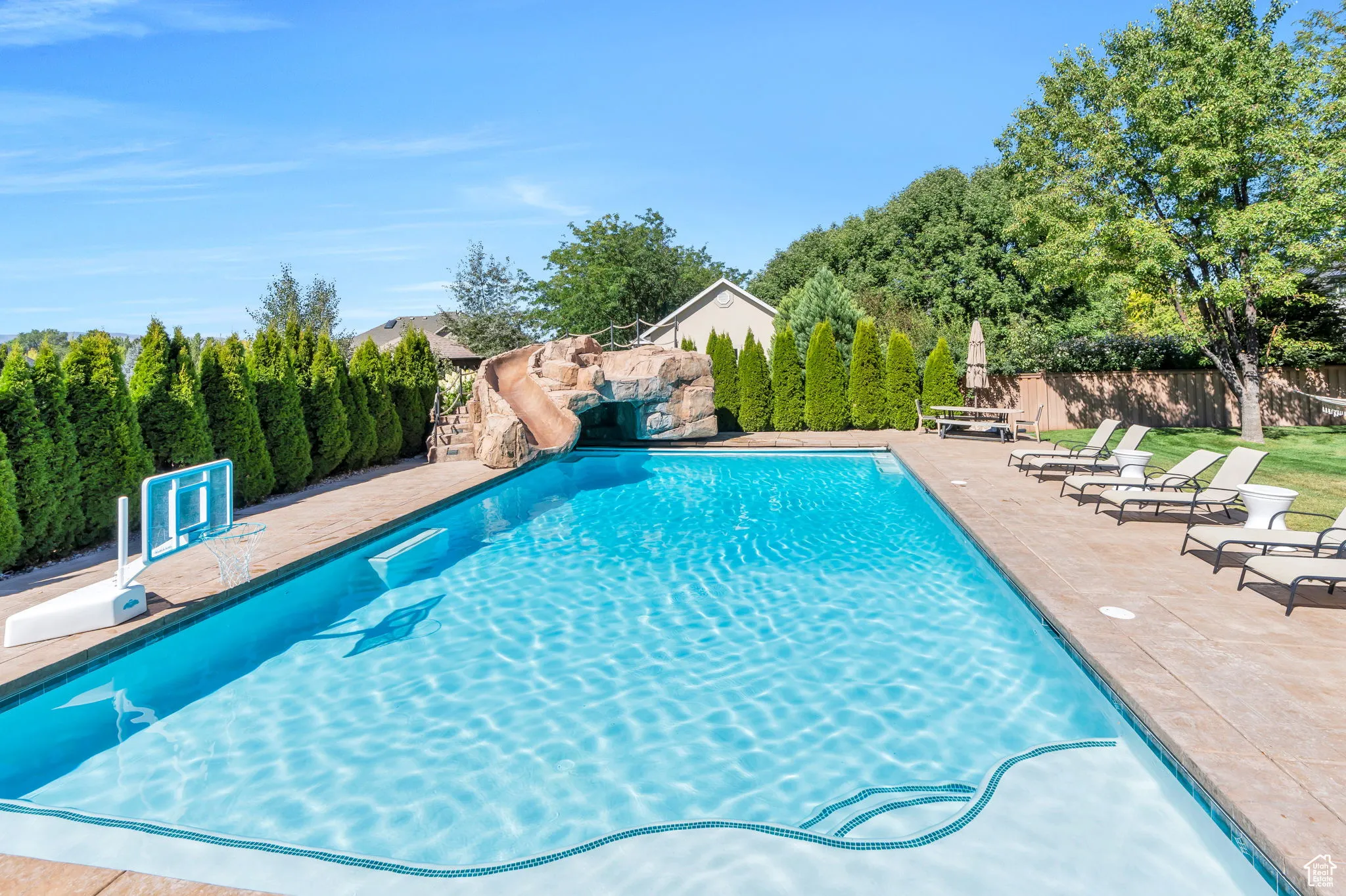 View of swimming pool with a water slide and a patio area
