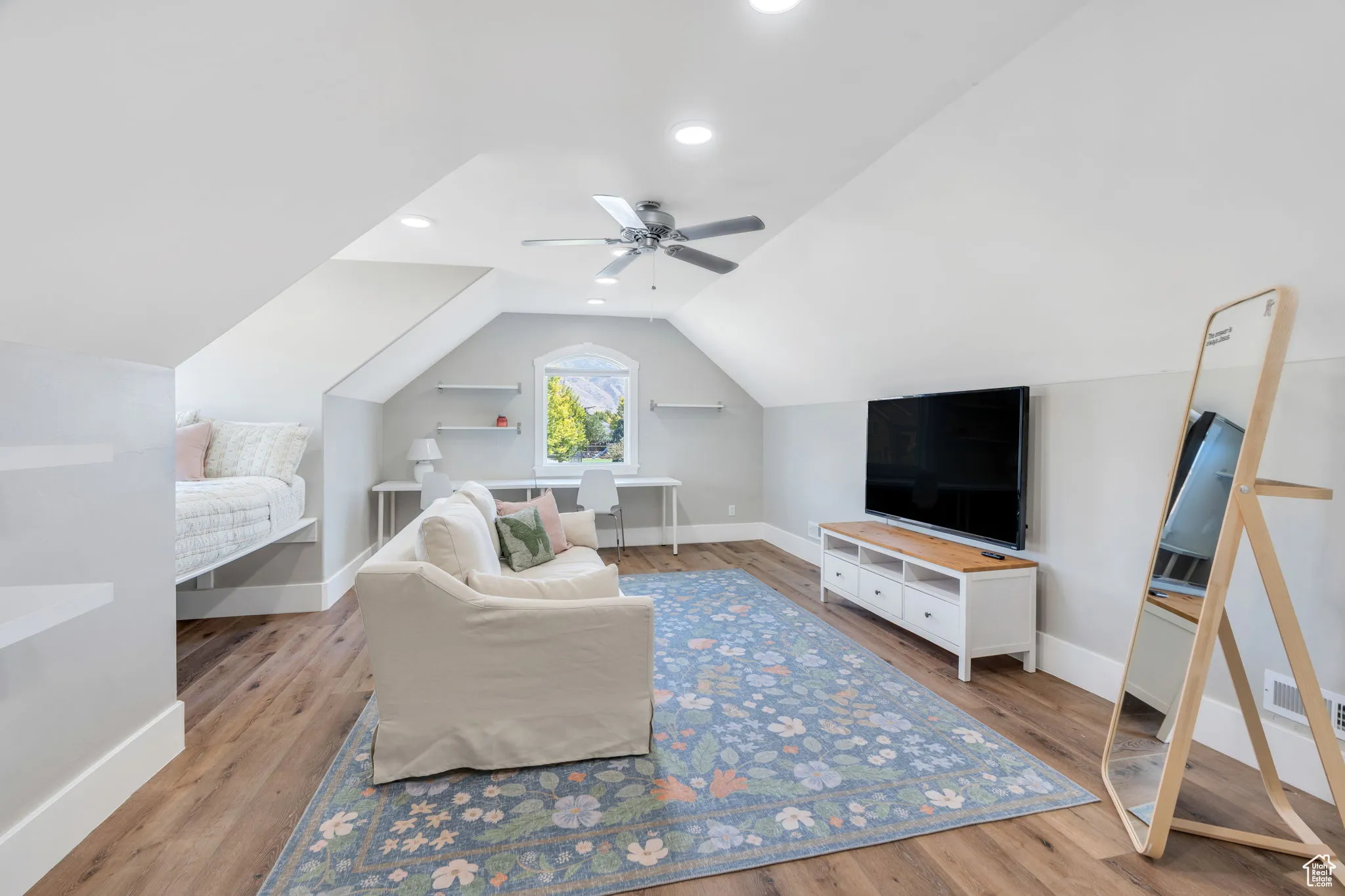 Living room featuring light wood-type flooring, vaulted ceiling, and recessed lighting