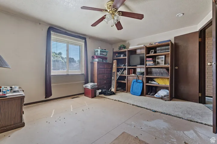 Sitting room with a textured ceiling and ceiling fan