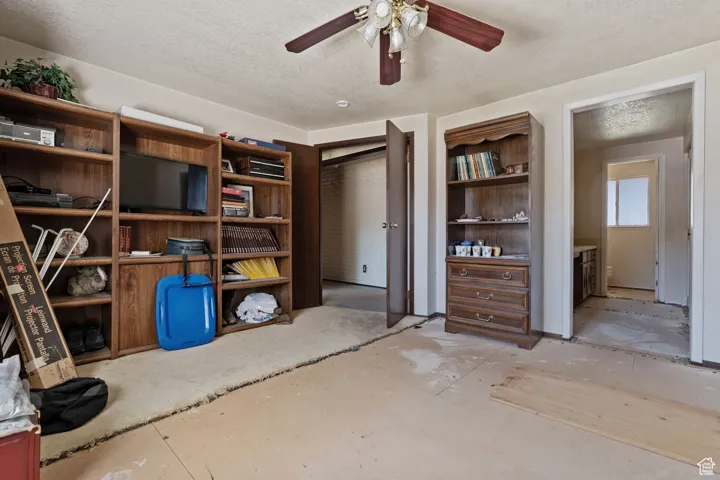 Living area with a textured ceiling and ceiling fan