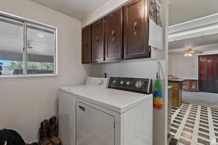 Washroom featuring cabinet space, a ceiling fan, and separate washer and dryer