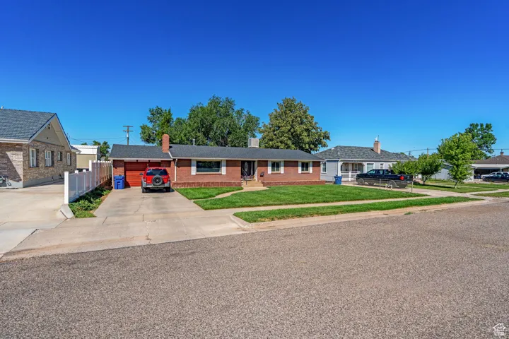 View of front of house with concrete driveway and brick siding