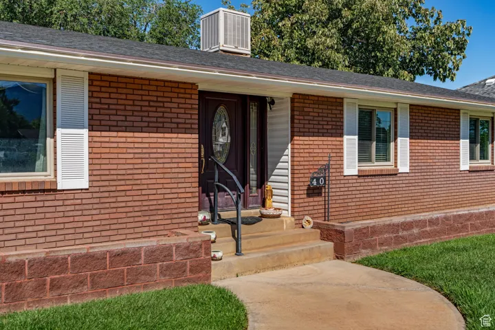 View of front of property featuring brick siding and a chimney