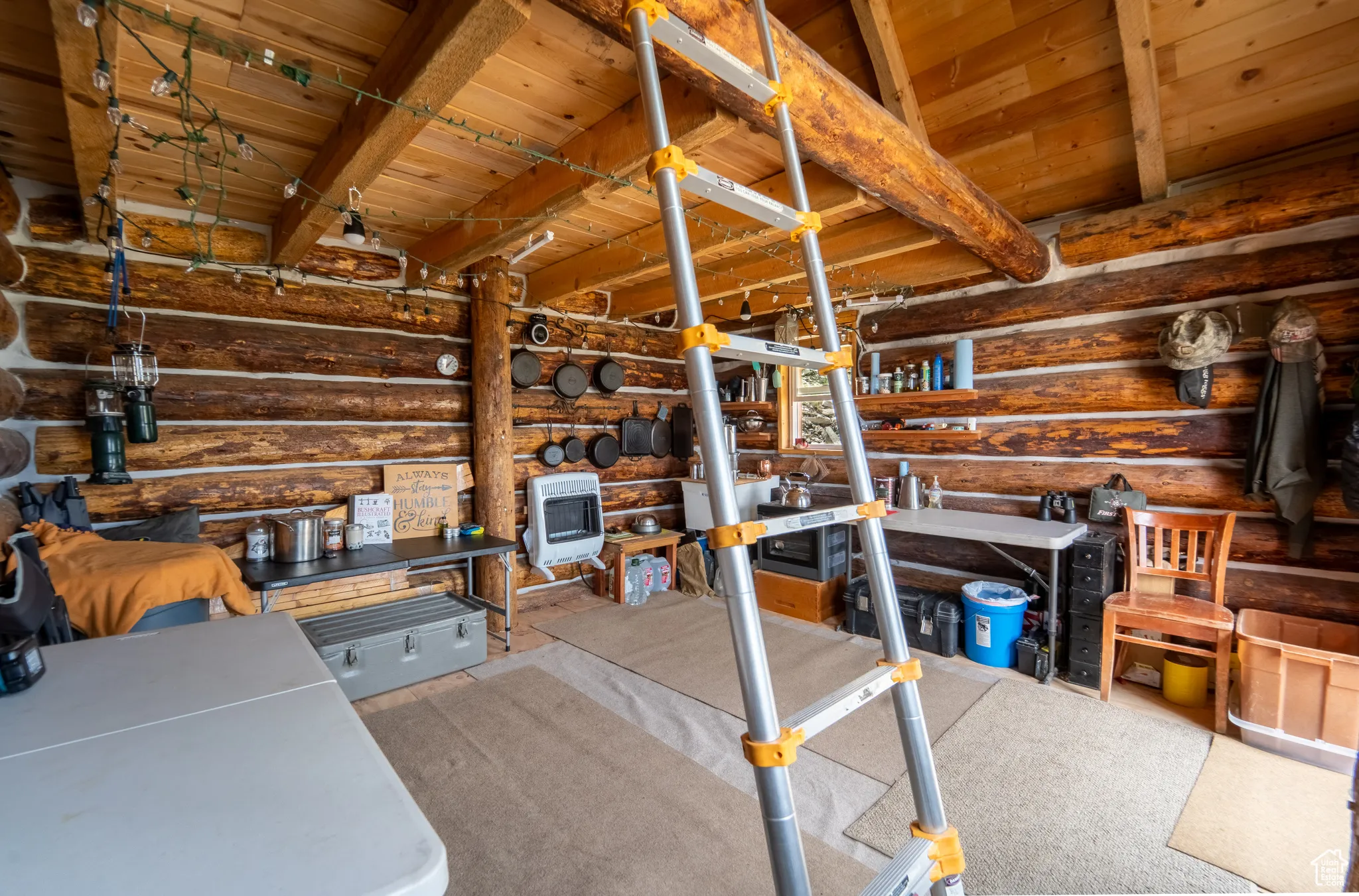 Unfurnished living room featuring log walls, heating unit, and a wood ceiling with exposed beams