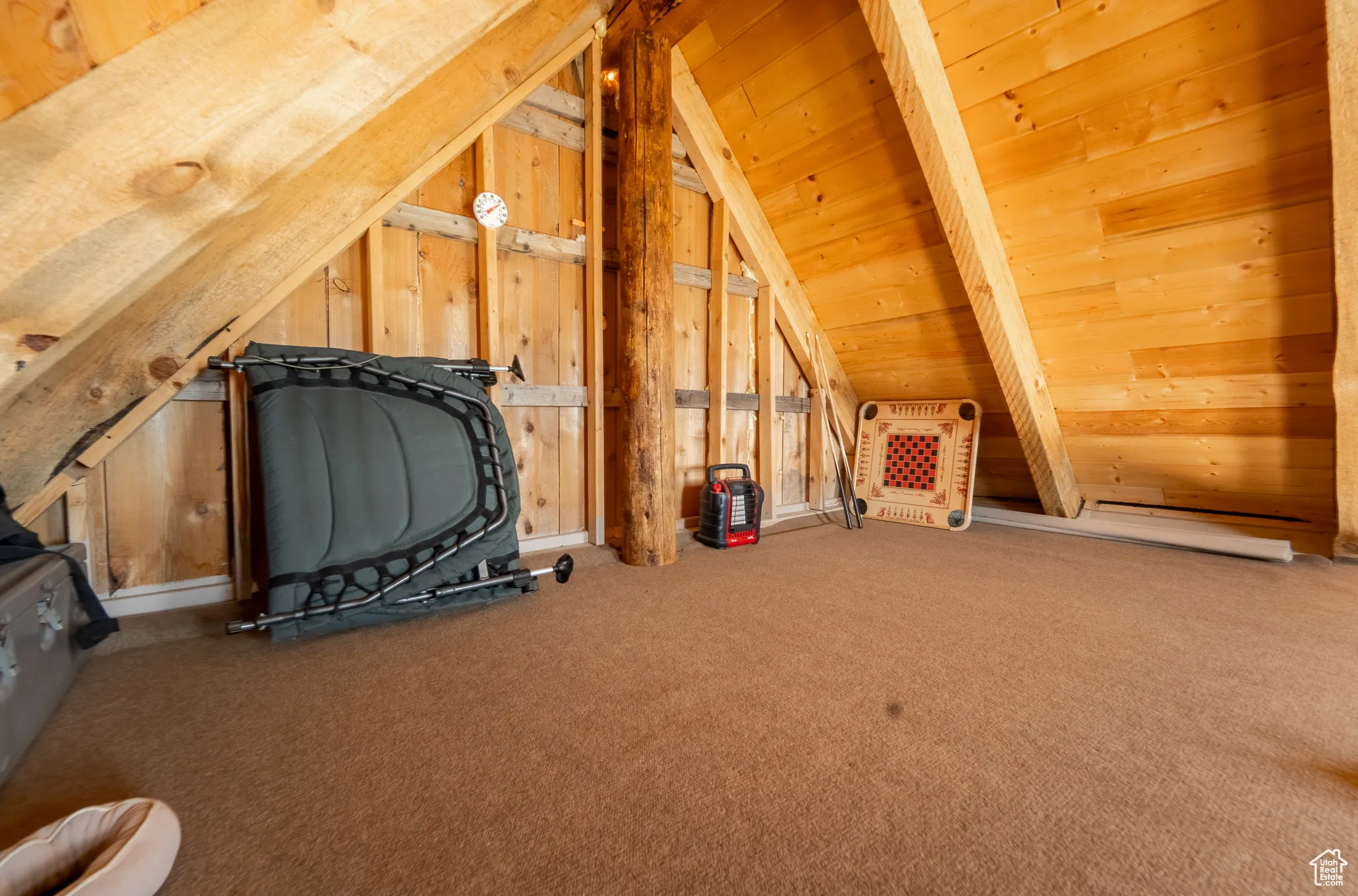 Additional living space with lofted ceiling, carpet floors, wood walls, and heating unit