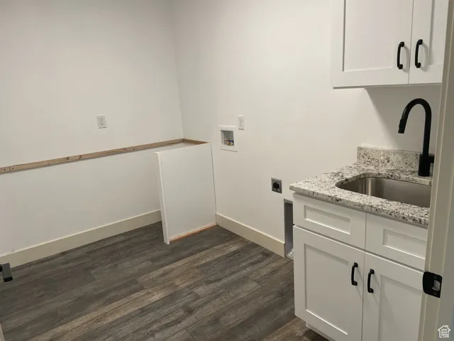 Washroom featuring cabinet space, dark wood finished floors, hookup for a washing machine, and electric dryer hookup