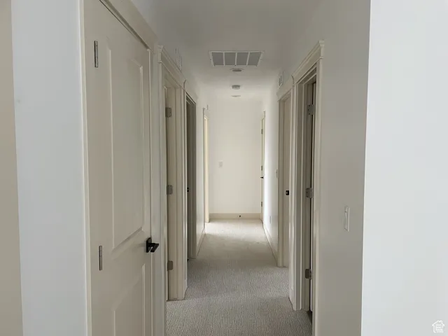 Hall featuring light colored carpet