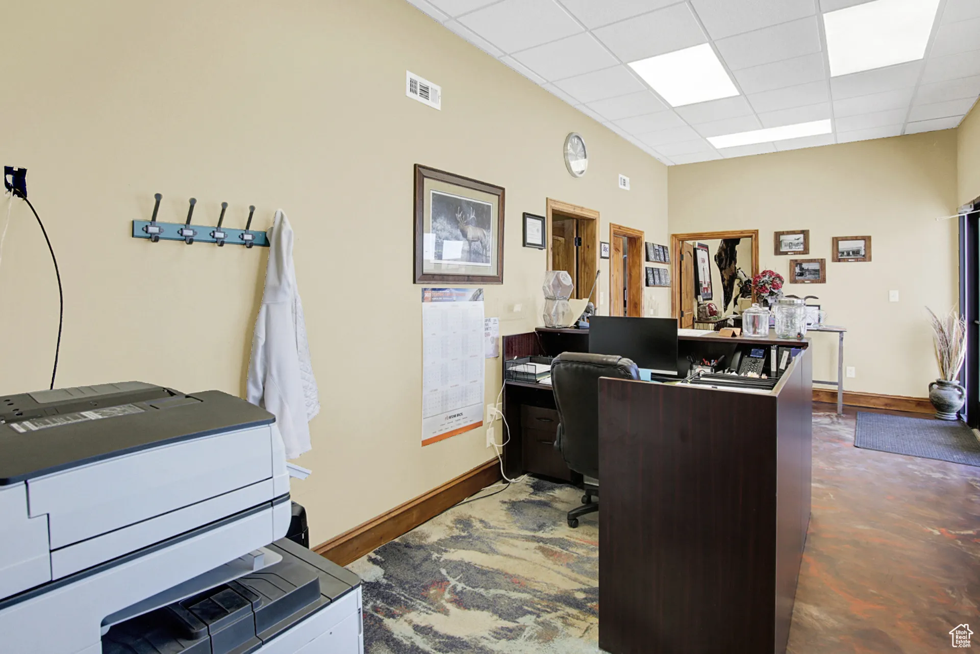 Office space featuring a drop ceiling and concrete floors