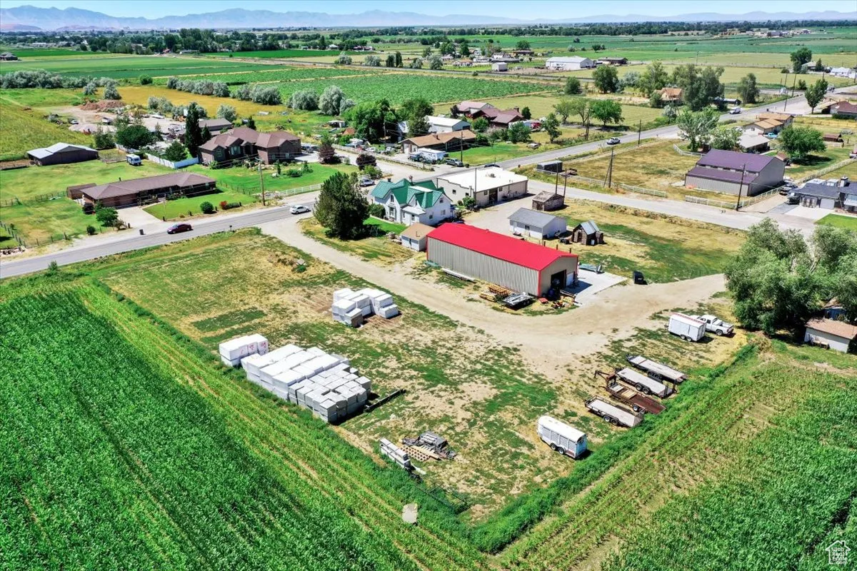 Aerial view of sparsely populated area featuring rows of crops and mountains