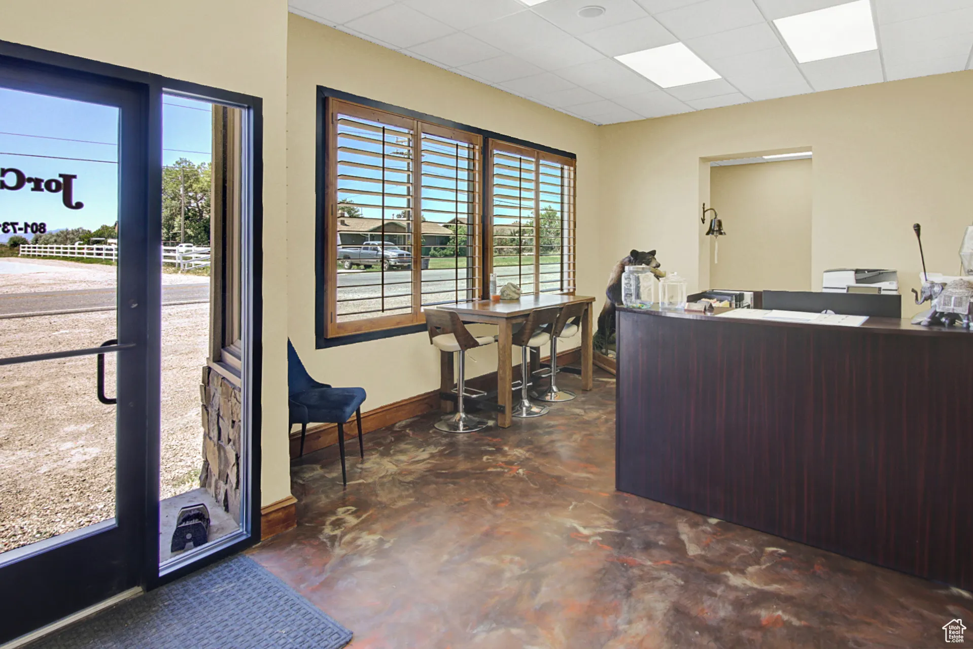 Home office with finished concrete floors and a drop ceiling