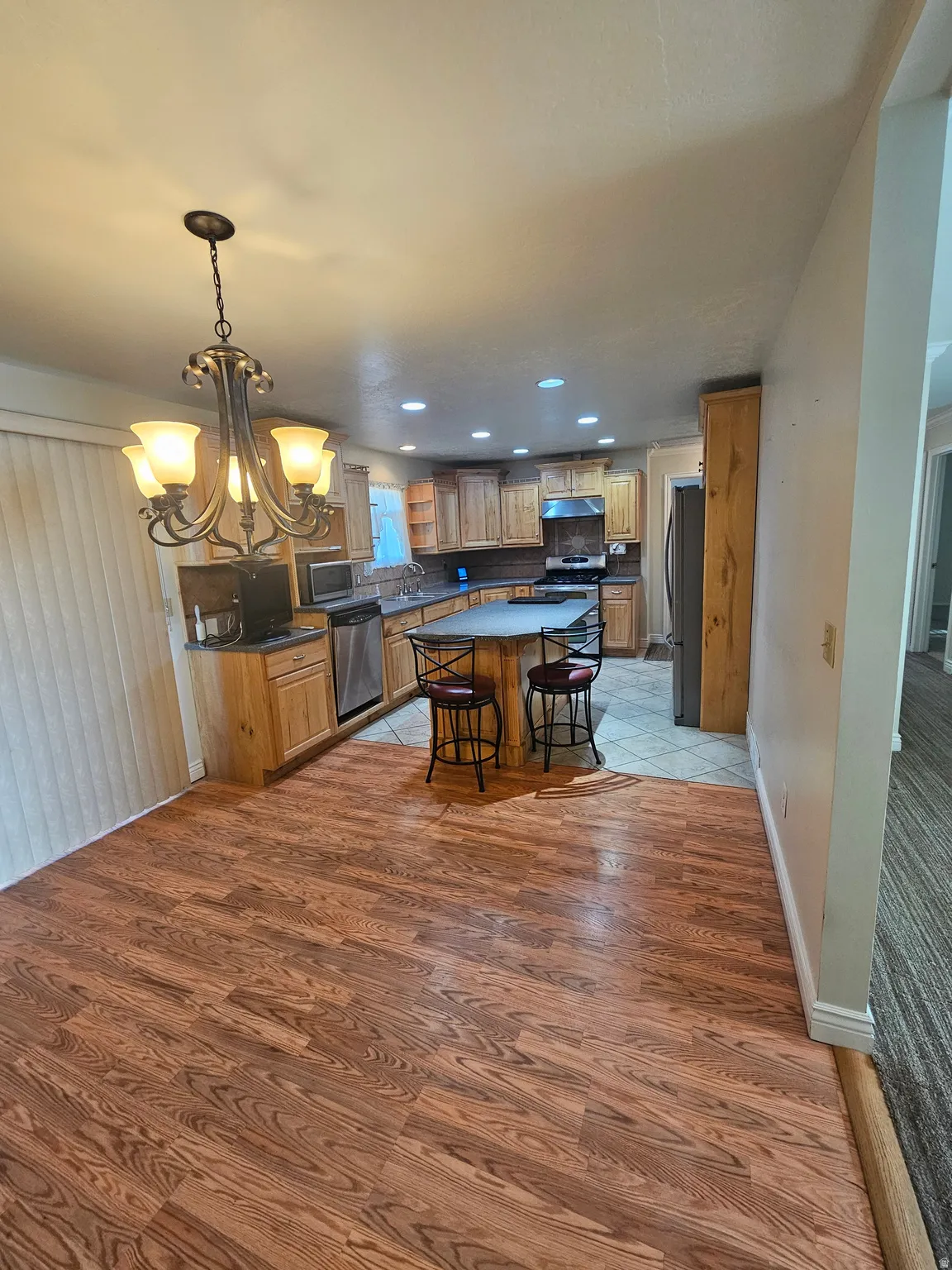 Kitchen with a chandelier, a kitchen bar, recessed lighting, light wood-type flooring, and hanging light fixtures