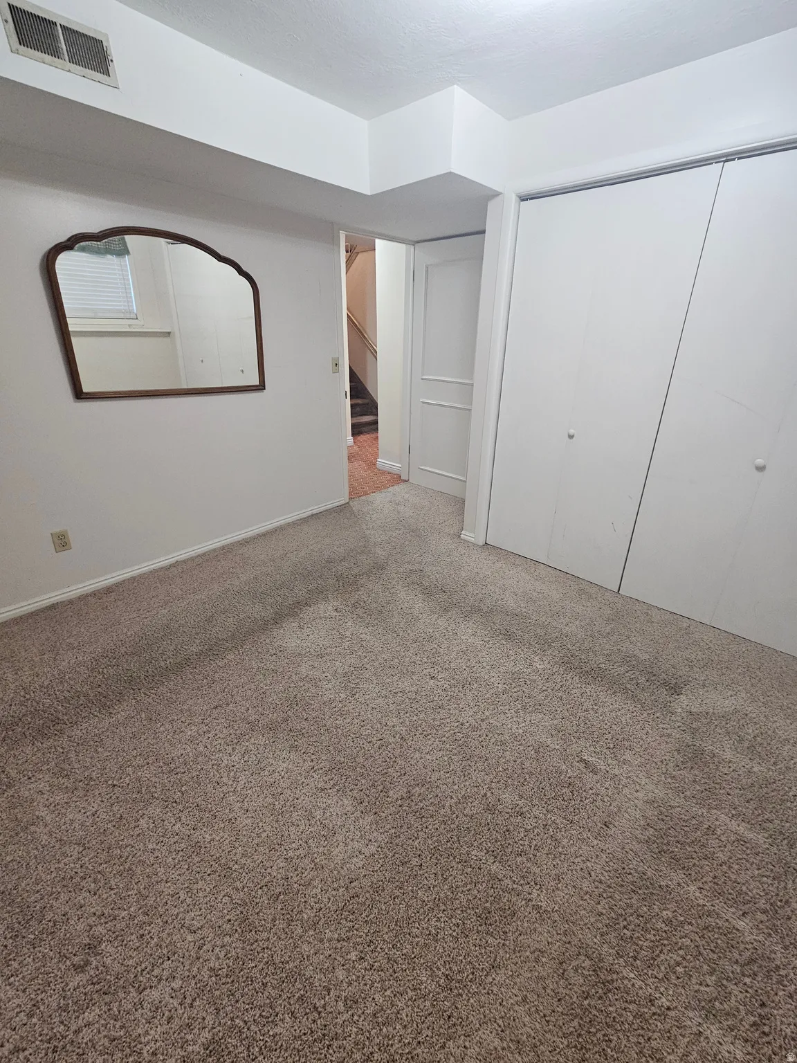Unfurnished bedroom featuring carpet flooring and a closet