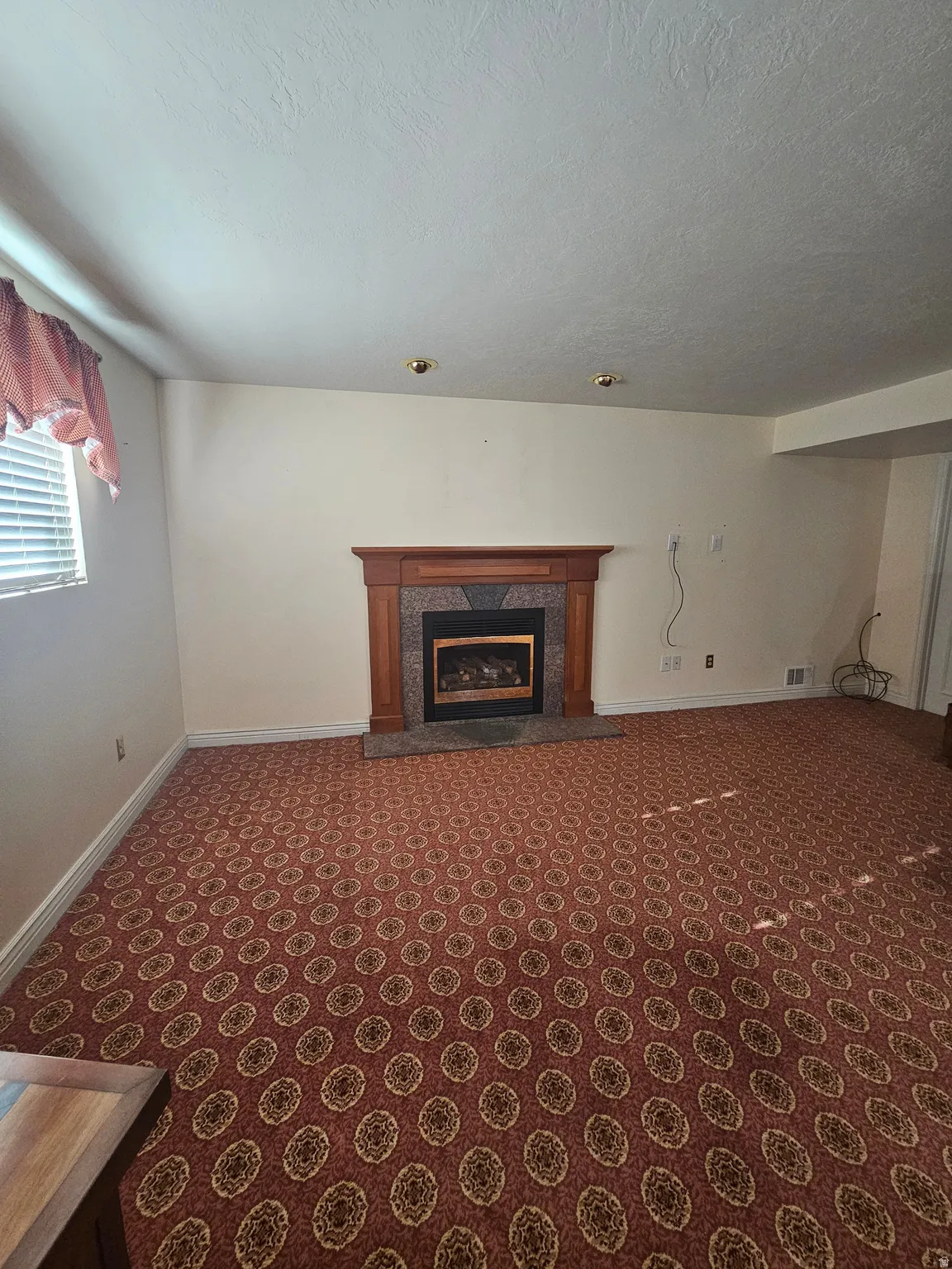 Unfurnished living room with a fireplace and carpet floors