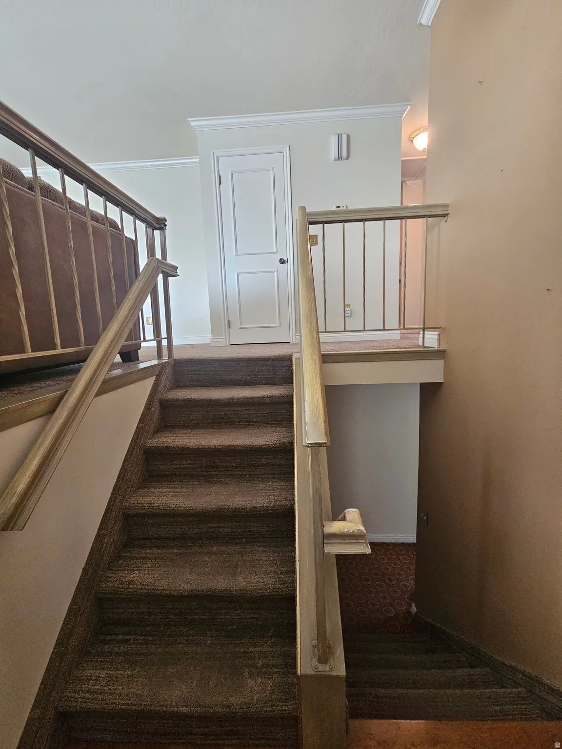 Stairway featuring crown molding and baseboards