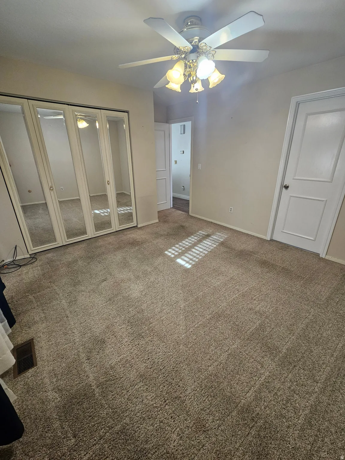 Unfurnished bedroom with carpet floors and ceiling fan