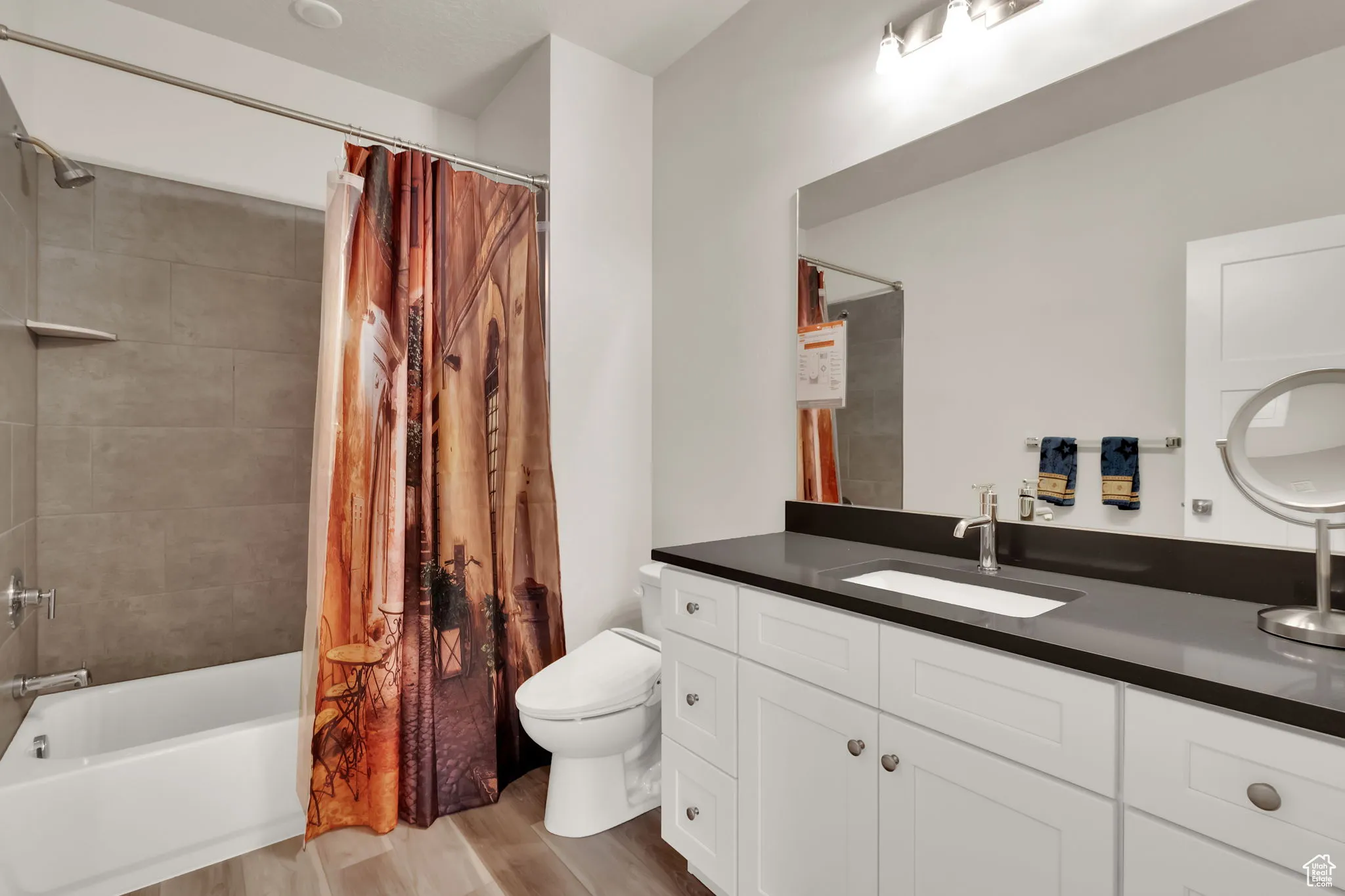 Full bathroom featuring shower / tub combo, vanity, and light wood-style LVP floors