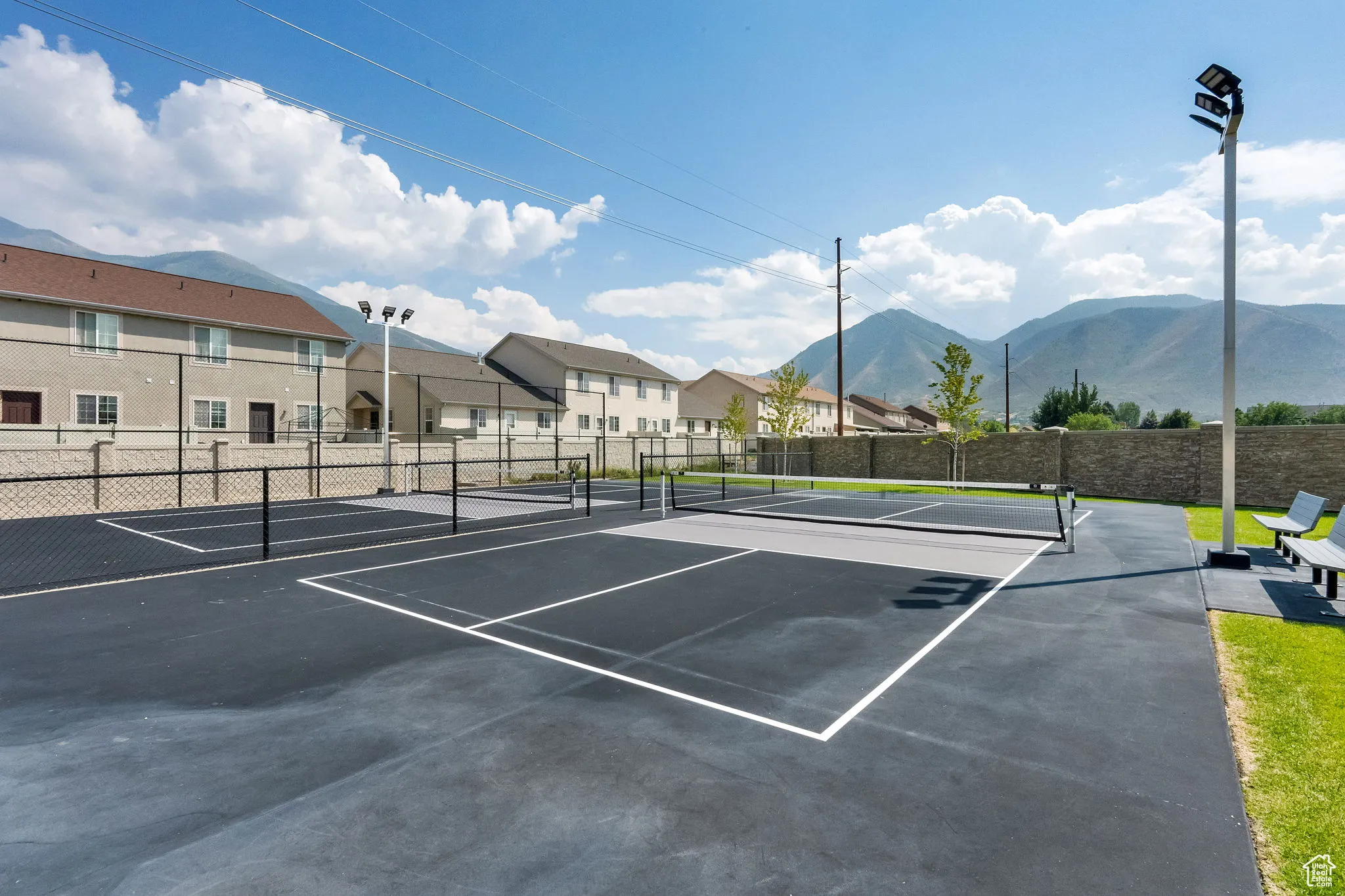 View of tennis court featuring a residential view, a mountain view, and community basketball court
