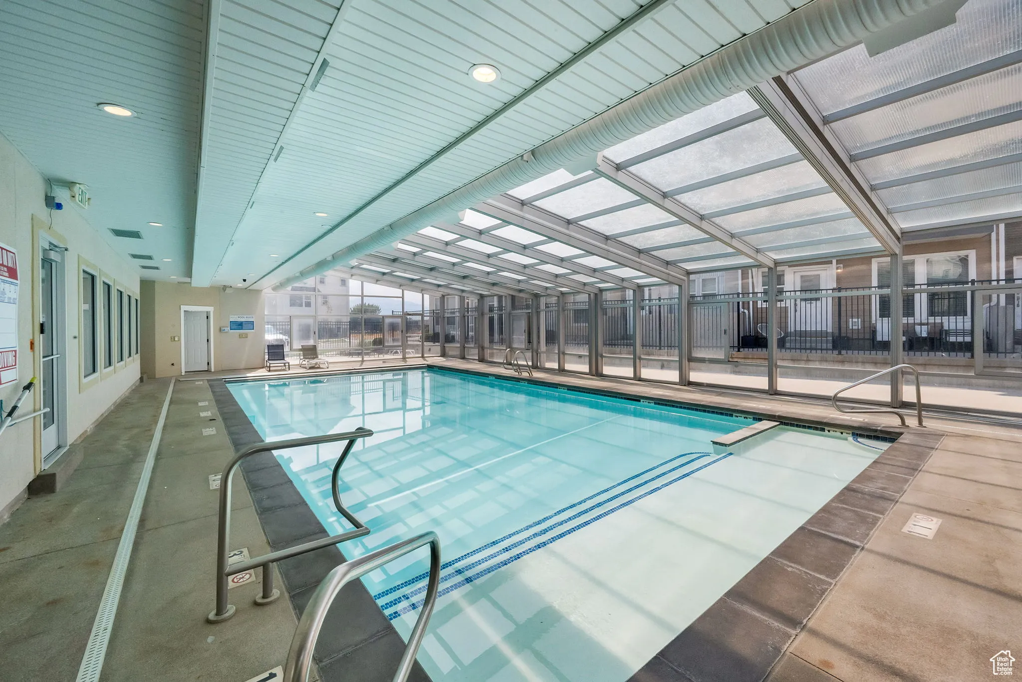 Indoor community pool featuring a patio and glass enclosure which retracts for year round use!