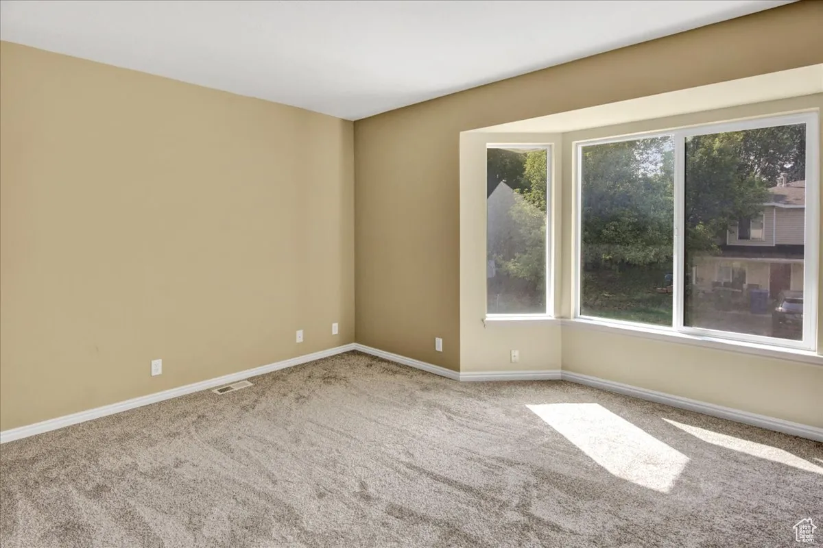 Empty room featuring carpet and baseboards