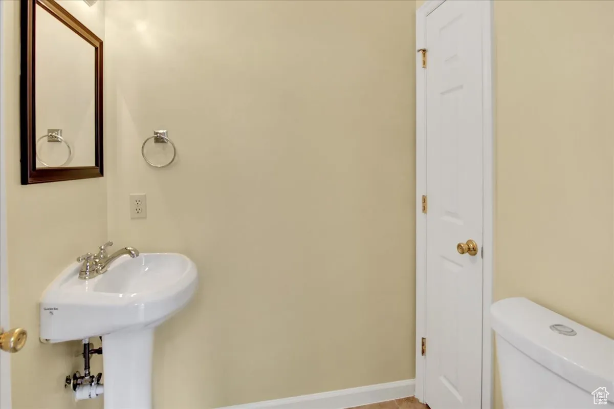 Half bath with toilet and baseboards