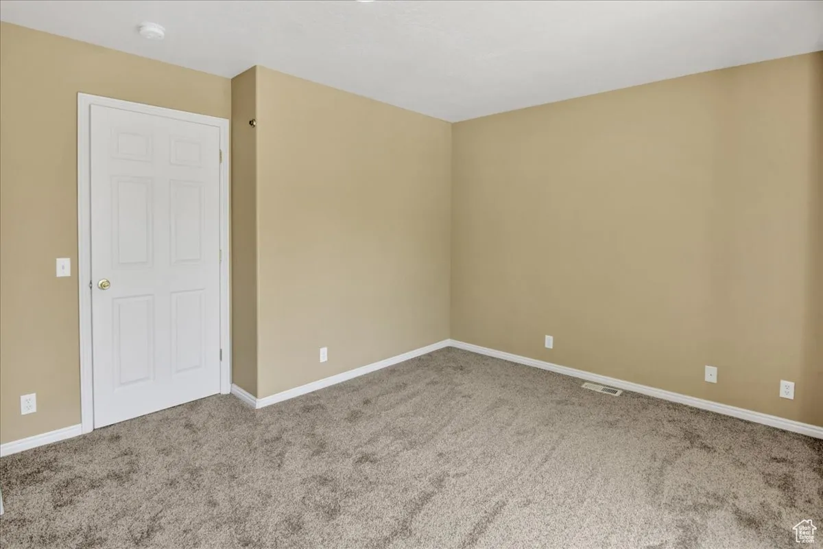 Carpeted spare room with baseboards