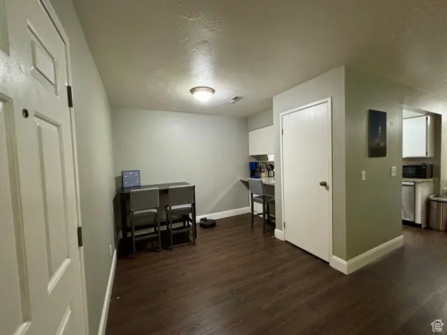 Office space featuring a textured ceiling and dark wood-style flooring