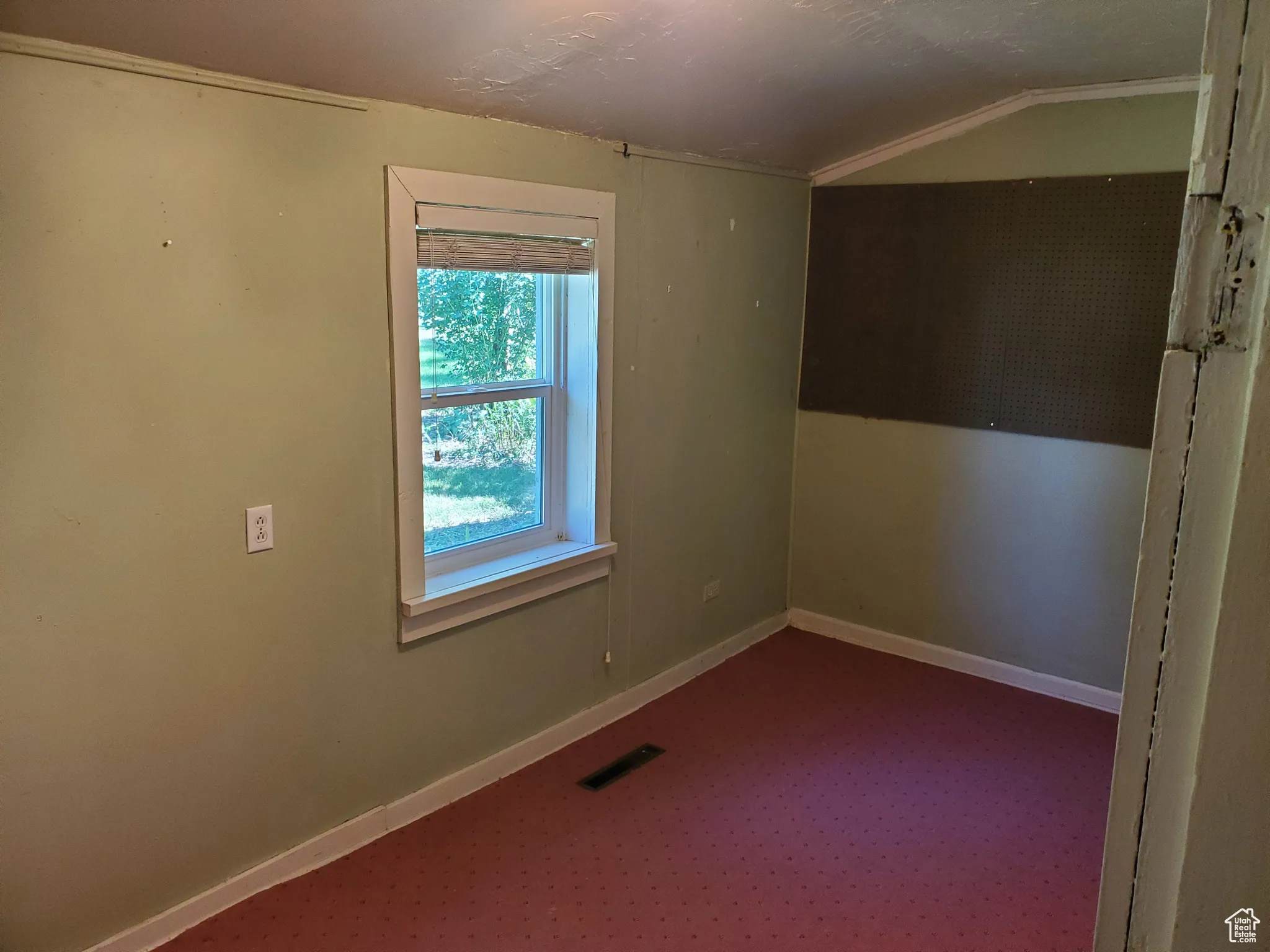 Spare room with dark carpet and vaulted ceiling