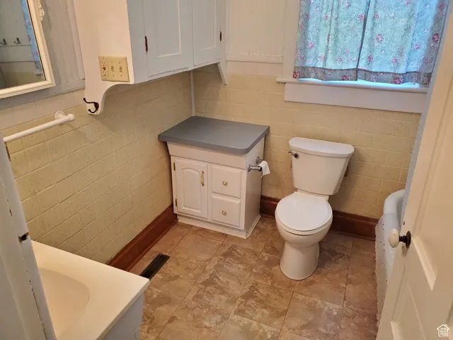 Half bath featuring vanity and tile walls