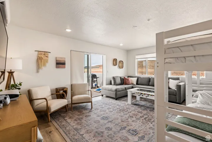 Living room featuring light wood-style flooring, a textured ceiling, and recessed lighting