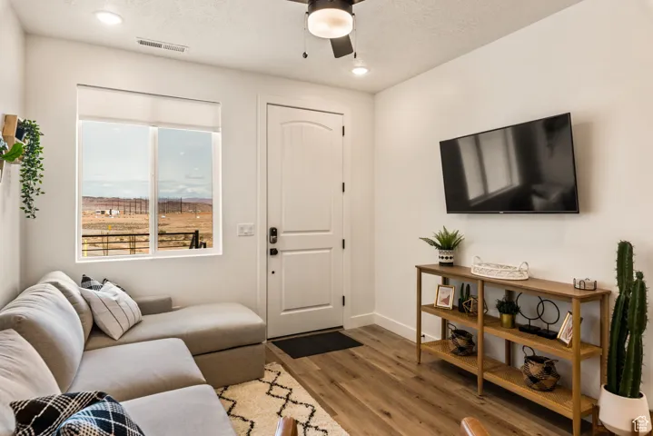 Living area with wood finished floors, a textured ceiling, ceiling fan, and recessed lighting
