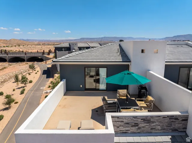 Top of house with a patio, a mountain view, and stucco siding