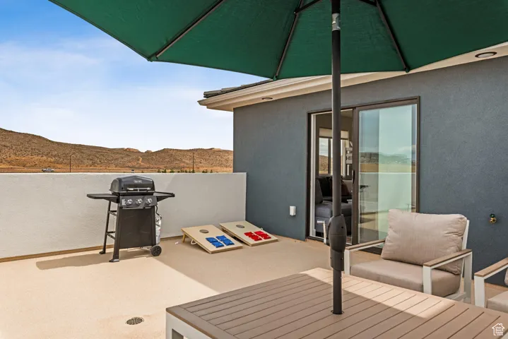 View of patio with a mountain view and area for grilling