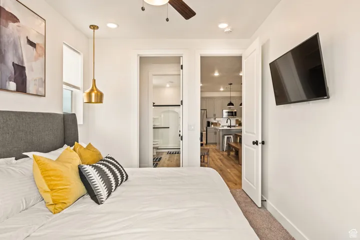 Bedroom featuring recessed lighting, light carpet, ceiling fan, and connected bathroom