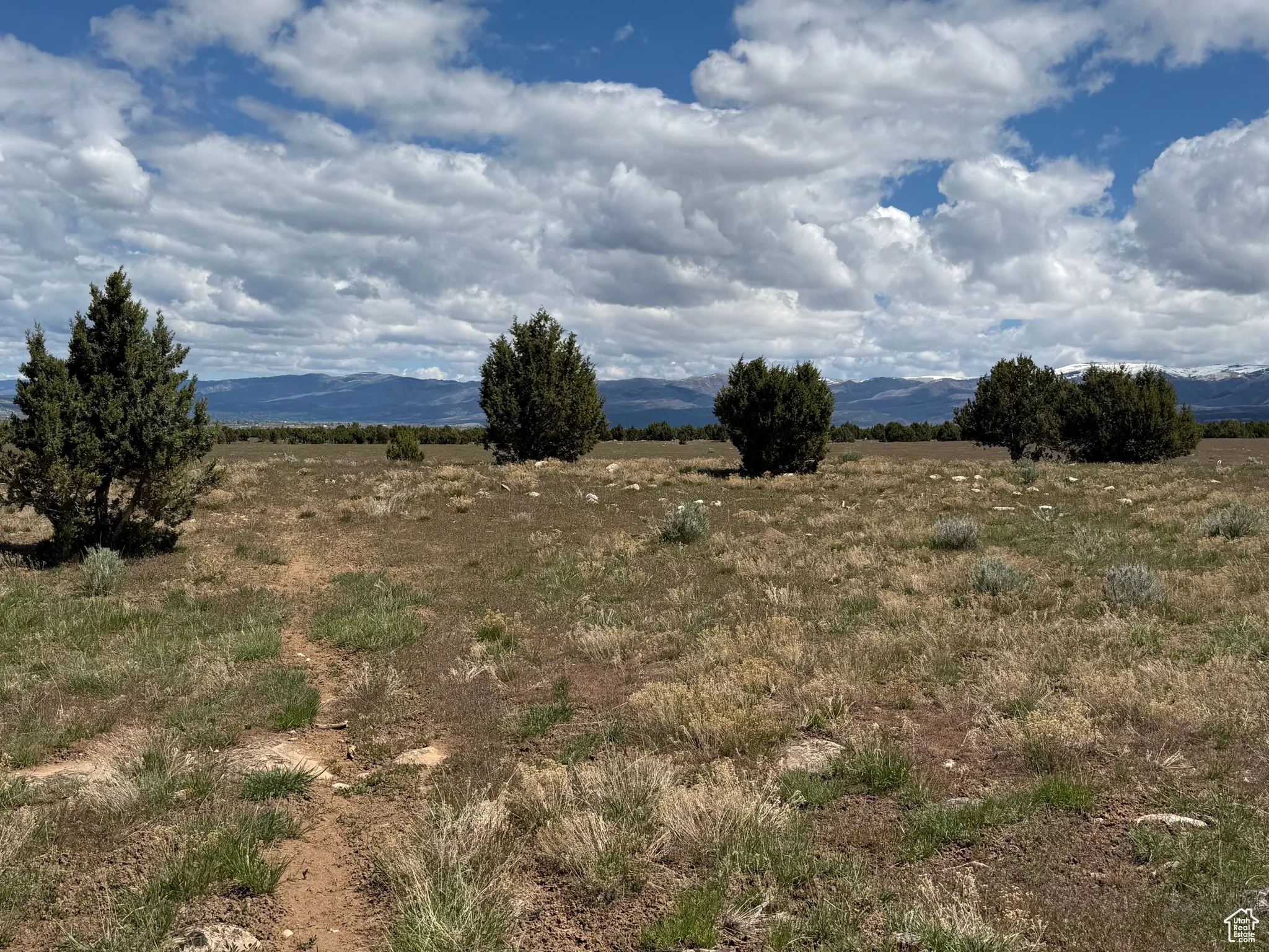 View of undeveloped land featuring a mountainous background and rural landscape