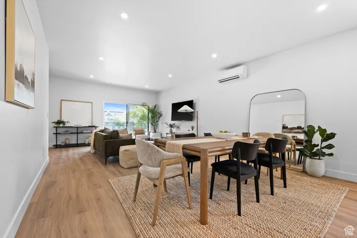 Dining area featuring recessed lighting, light wood finished floors, and a wall unit AC