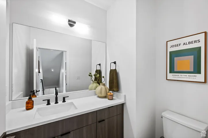 Half bathroom featuring vanity and toilet