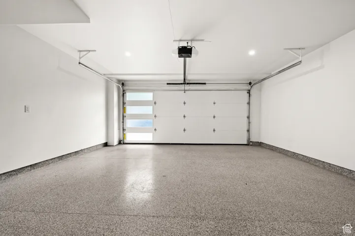 Garage with baseboards and a garage door opener, with EV charging
