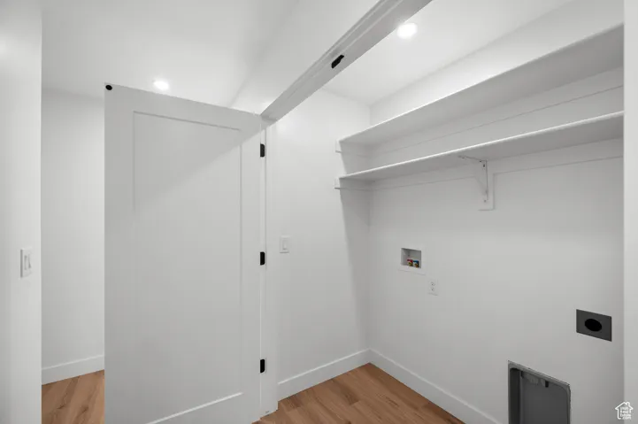 Laundry room featuring light wood-type flooring, washer hookup, hookup for an electric dryer, and recessed lighting