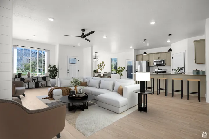Living area featuring light wood finished floors, ceiling fan, and recessed lighting (vr staging)